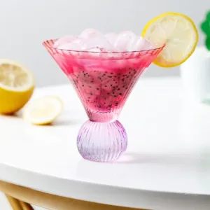 Verre à cocktail design avec un élégant motif strié et une boisson colorée, parfait pour des martinis et cocktails sophistiqués