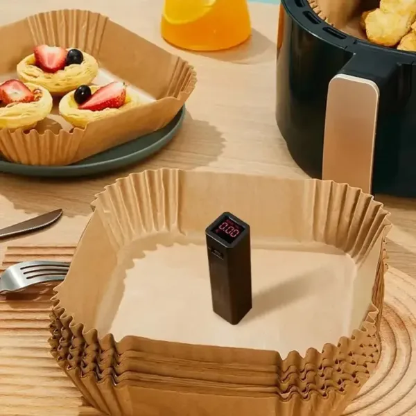 Papier cuisson pour friteuse à air, en forme carrée avec bords plissés, idéal pour une cuisson sans huile