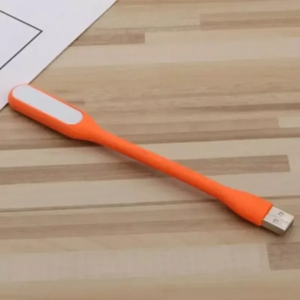 Lampe USB flexible LED orange sur un bureau en bois