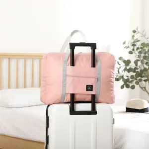 Sac de voyage pliable et léger fixé sur une valise pour déplacements pratiques.