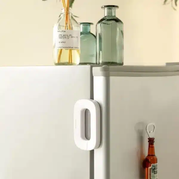 Verrou de sécurité adhésif pour réfrigérateur installé sur une porte