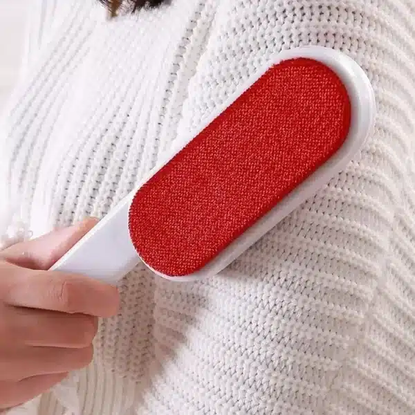 Brosse anti poils et anti peluches utilisée pour retirer les peluches sur un pull