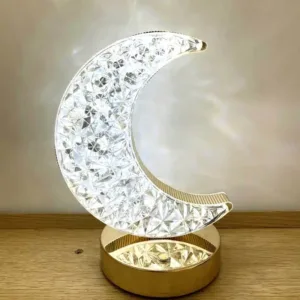 Lampe décorative en forme de lune avec éclairage LED cristallin, posée sur une table en bois.