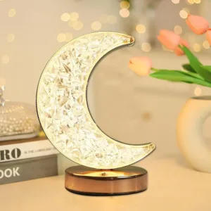 Lampe décorative en forme de lune avec éclairage LED cristallin, posée sur une table en bois.