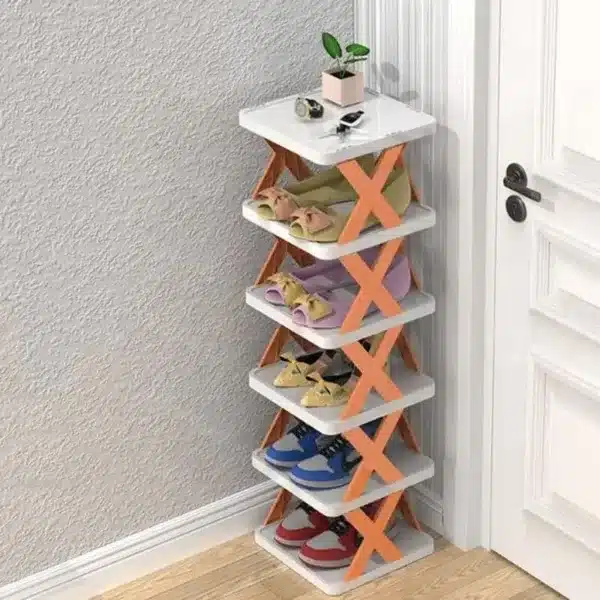 Étagère à chaussures compacte à 6 niveaux, rangée dans un coin près d'une porte, avec plusieurs paires de chaussures organisées.