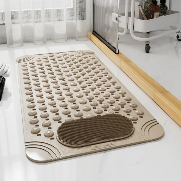 Tapis de bain antidérapant beige avec ventouses et surface massante, installé dans une salle de bain pour plus de sécurité et de confort.