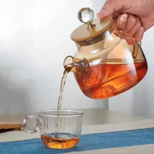 Théière en verre borosilicate avec couvercle doré pour infusions élégantes.