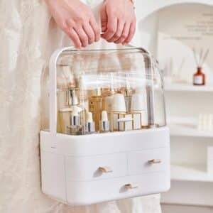 Organisateur maquillage rose avec couvercle transparent et tiroirs pour cosmétiques et accessoires.