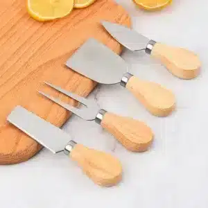 Set d’ustensiles à fromage avec manches en bois et lames en acier inoxydable sur une planche.