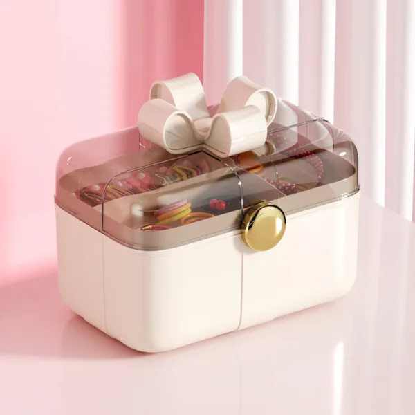 Boîte de rangement pour bijoux avec couvercle transparent et nœud décoratif.