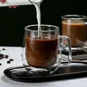 Tasse en verre double paroi avec café et lait versé