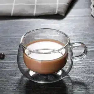 Tasse en verre double paroi avec café et lait versé