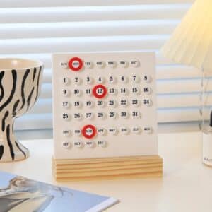 Calendrier perpétuel design moderne avec support en bois clair et anneaux de date