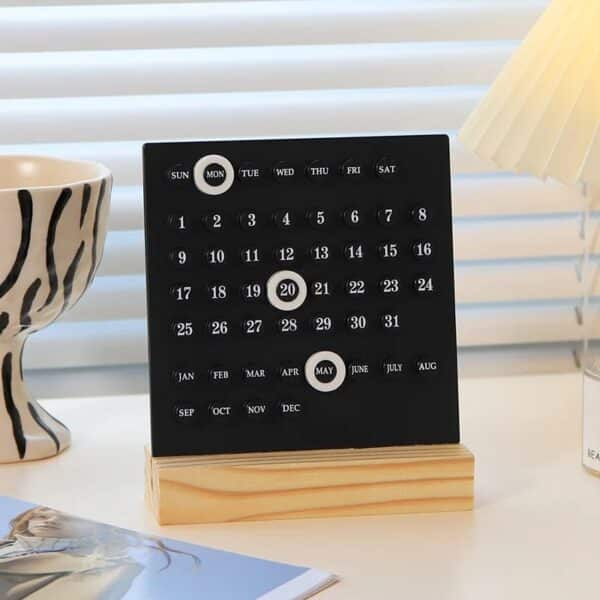 Calendrier perpétuel design moderne avec support en bois clair et anneaux de date