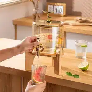 Distributeur de boisson en verre avec robinet doré et support en bois design