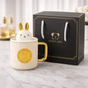 Mug lapin avec couvercle en céramique noire et anse dorée présenté avec coffret cadeau