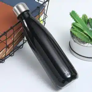 bouteille isotherme inox 500ml couleur bleu nuit posée à côté d’un carnet et d’un cactus
