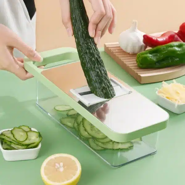 mandoline de cuisine multifonction avec bac, râpe à légumes verte en action sur plan de travail