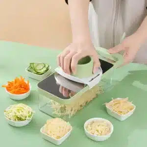 mandoline de cuisine multifonction avec bac, râpe à légumes verte en action sur plan de travail