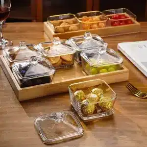 Plateau en bois avec bocaux en verre transparent remplis de fruits secs, bonbons et gâteaux – Présentoir élégant pour apéritif au Maroc
