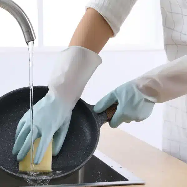 Gants de vaisselle antidérapants bleus utilisés pour laver une poêle dans un évier