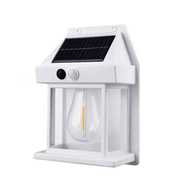 lampe-solaire-murale-avec-detecteur-de-mouvement-blanc Lampe solaire murale blanche avec détecteur de mouvement, installée sur un mur extérieur et émettant une lumière chaude.