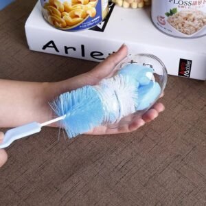 Brosse nettoyage biberon et tétine utilisée pour nettoyer un couvercle de biberon violet