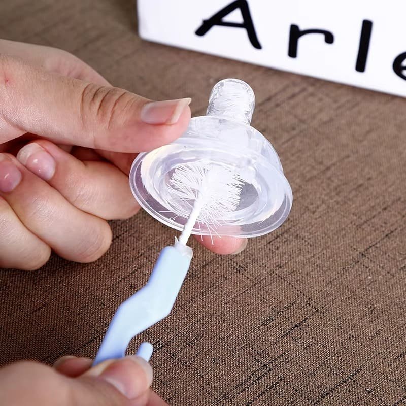 brosse-nettoyage-biberon-et-tetine-rose-2 Brosse nettoyage biberon et tétine utilisée pour nettoyer un couvercle de biberon violet