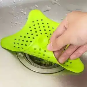 Filtre évier silicone Maroc en forme d’étoile posé dans un évier avec l’eau qui coule