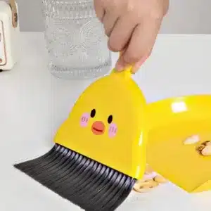 Mini balayette pelle Maroc en forme de canard jaune posée sur une table