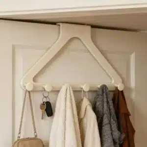 porte manteau de porte beige à 5 crochets suspendu sur une porte avec manteaux écharpes et clés dans une maison au maroc