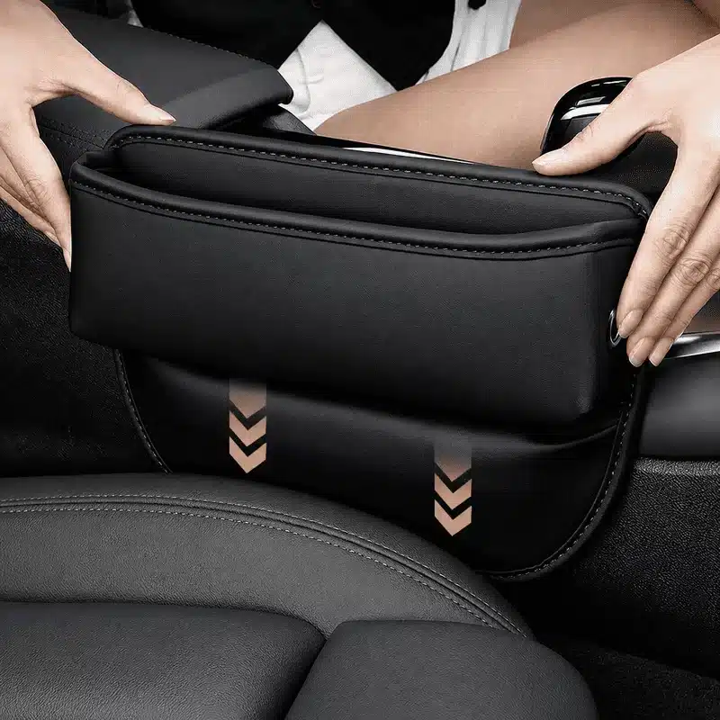 organisateur-de-siege-voiture-en-cuir-noir Organisateur de siège voiture en cuir noir installé entre le siège et la console centrale pour ranger téléphone, clés et accessoires.