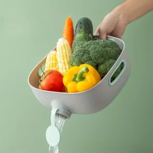 Bassine de cuisine grise avec bouchon de vidange et poignées intégrées pour laver et égoutter les fruits et légumes.