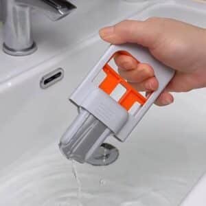 Raclette de nettoyage multifonction 2 en 1 pliable avec lame grise et poignée blanche et orange pour vitres, miroirs, carrelage et cuisine.